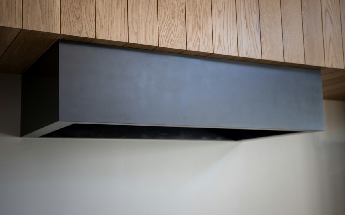 A stainless range hood mounted over a stove in a lived-in Baltimore, MD kitchen serviced by Doctor Maintenance