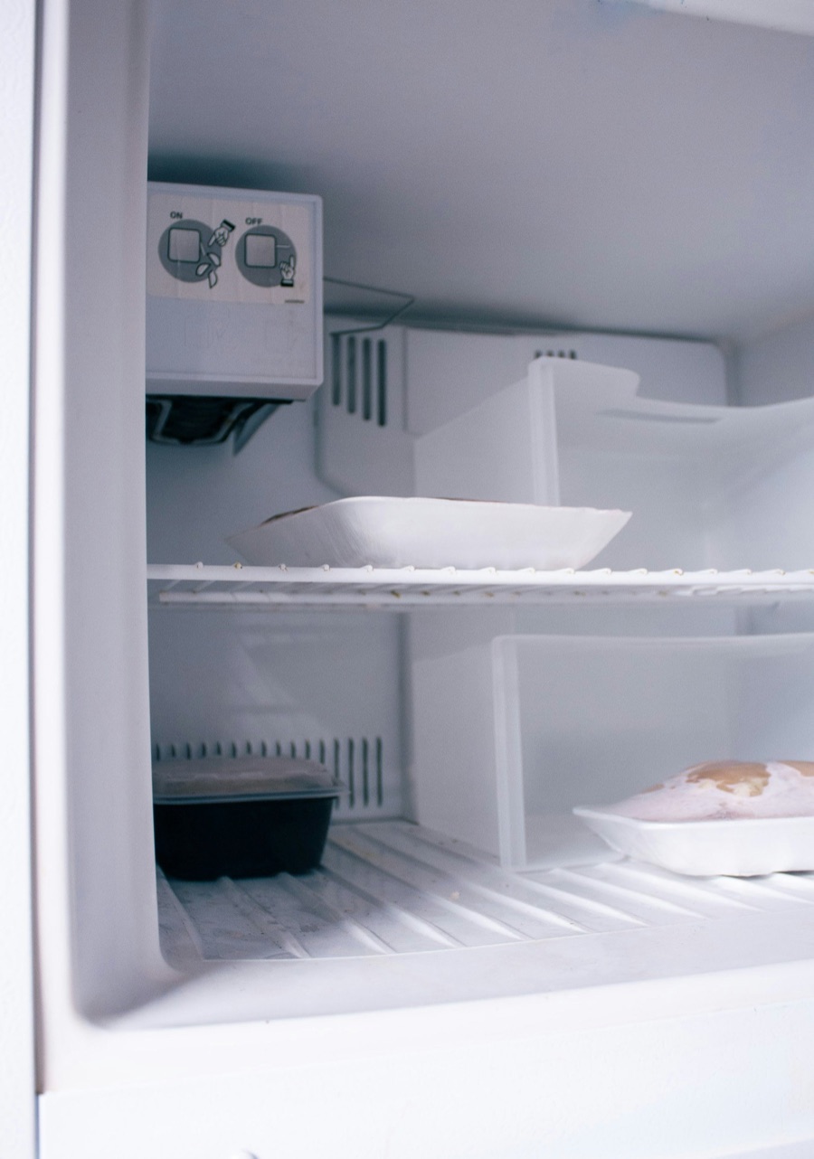 Interior de un refrigerador usado con la perilla de temperatura y comida en las repisas, el tipo de refri que Doctor Maintenance repara por todo Baltimore, MD